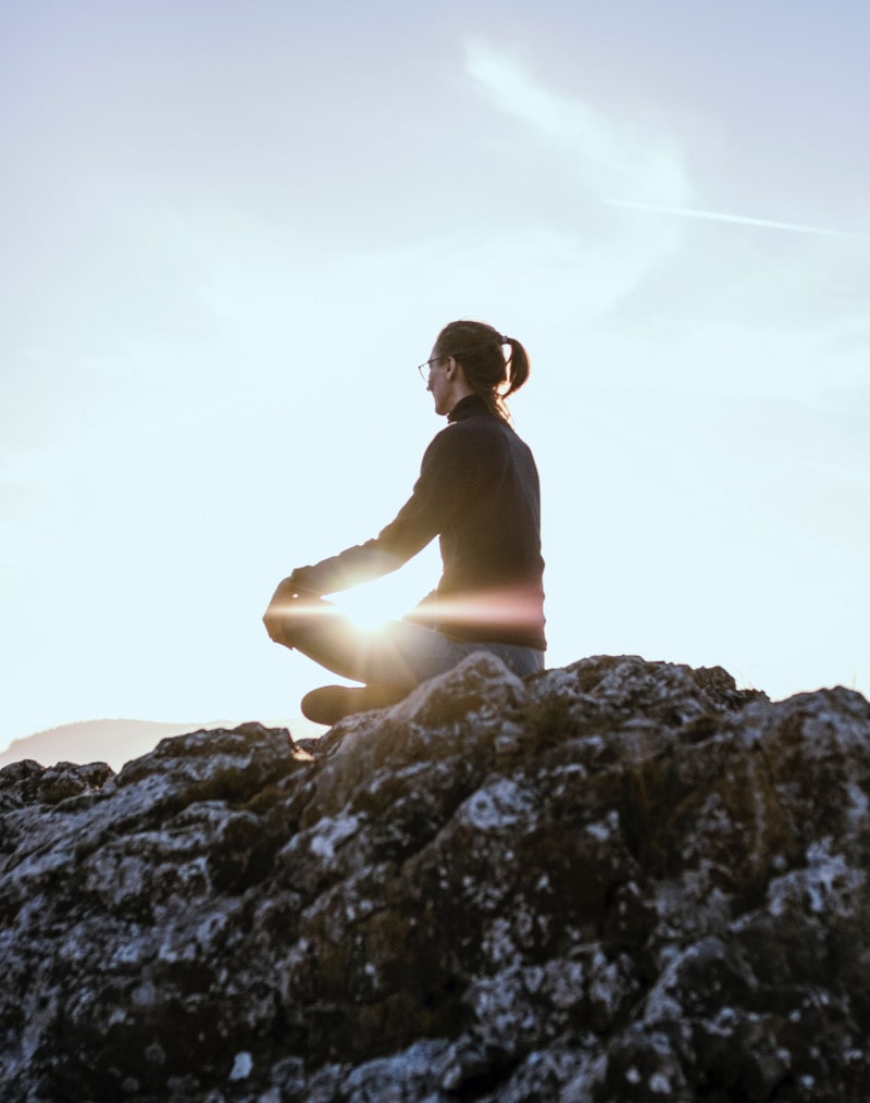 Denver dispensary | woman meditating in the mountains