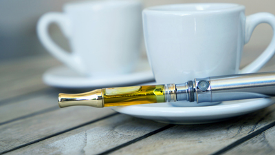 weed pen next to a cup of coffee