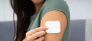 woman applying transdermal patch to arm